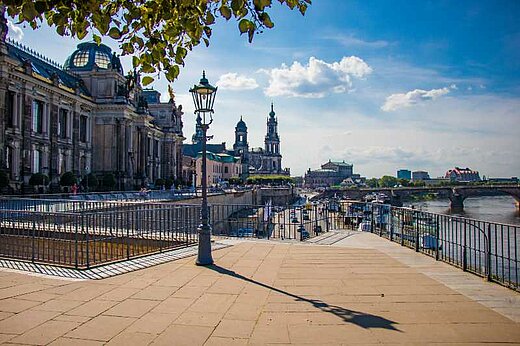 Brühlsche Terrasse in Dresden View from standing on the Brühlsche Terrasse in Dresden towards the Academy of Fine Arts, the Dresden Cathedral, and the Semper Opera (on the left hand side) and the river Elbe (on the right hand side). In the foreground a treetop hanging into the picture and a gas lantern.